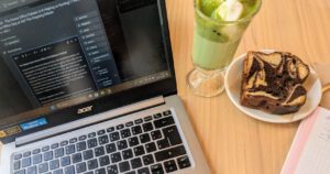 Title image The home office debate / Photo of laptop, matcha latte and cake